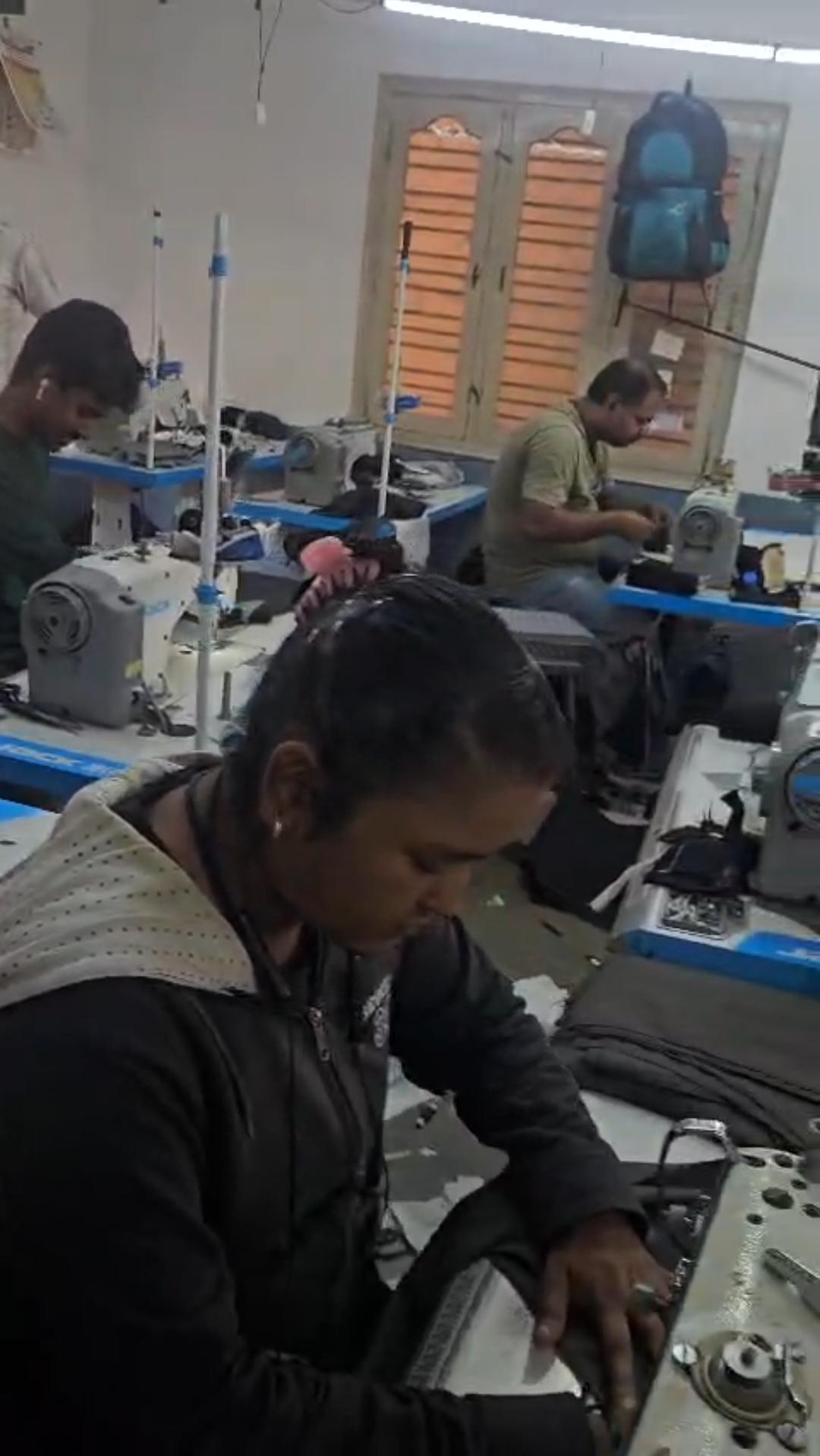 Tailor stitching a garment at the factory